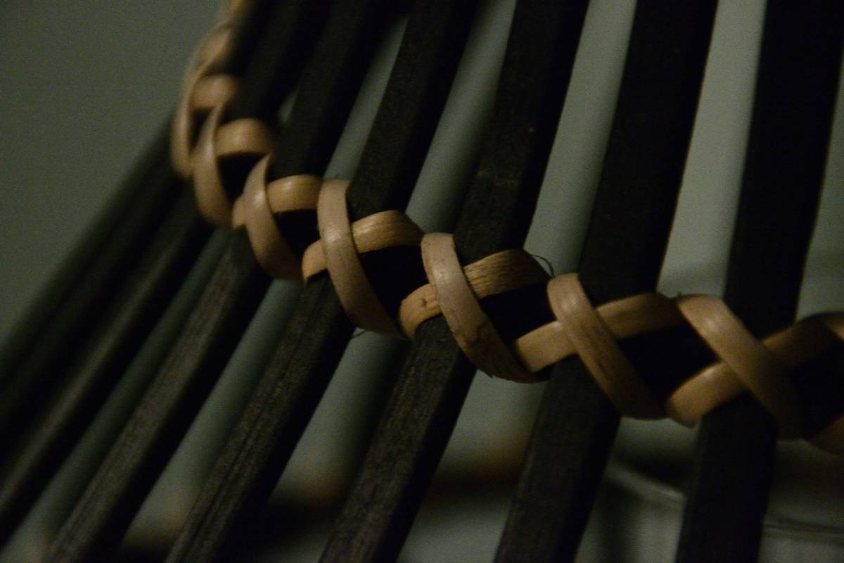 diy project wicker chair repair how: close-up of split rattan strands on vintage chair seat needing restoration